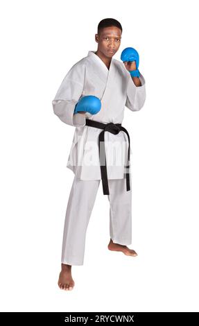 karate afroamericano in posizione, in piedi con la parte anteriore, in uniforme kimono bianca con cintura e guanti Foto Stock