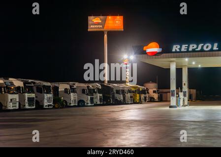 Stazione di servizio dell'azienda Repsol con una fila di camion che si riposano una notte. Foto Stock