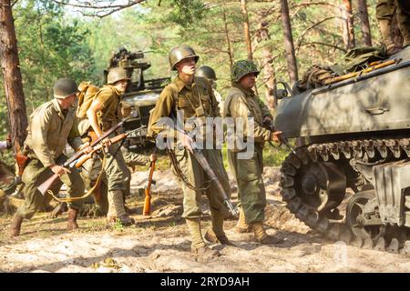 Hel, Pomerania, Polonia - 27 agosto 2023: Ricostruzione storica. Un soldato di fanteria americano della seconda guerra mondiale combatte nella foresta sotto il Foto Stock