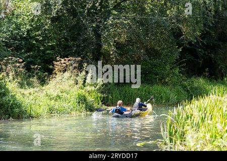 Attività ricreative nell'Hampshire - un uomo e una donna che fanno kayak su un gommone sul canale Basingstoke vicino a Odiham in un giorno d'estate. Inghilterra Foto Stock