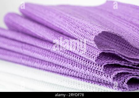 Tovagliolo sintetico da cucina color lavanda ripiegato su uno sfondo bianco. Primo piano Foto Stock