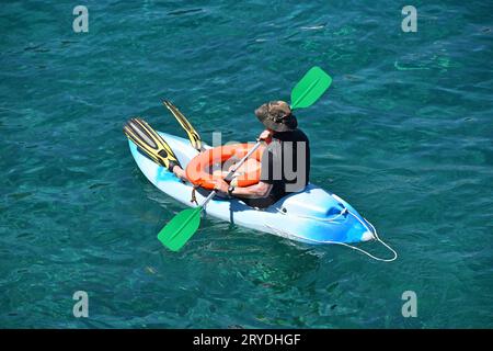 Bagnino sulla spiaggia in kayak boat in acqua di mare Foto Stock