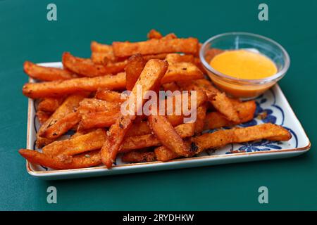 Porzione di patatine fritte o patatine fritte con salsa da immersione sul piatto sopra la tavola Foto Stock