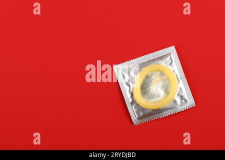 Primo piano di una confezione di preservativi su sfondo rosso Foto Stock