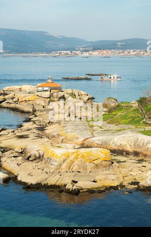 Rias Baixas seascape con Punta Faro Cabalo e barca di cozze Foto Stock