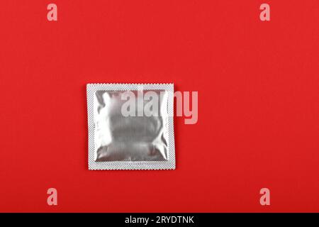 Primo piano di una confezione di preservativi su sfondo rosso Foto Stock