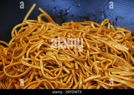 Chiudere gli spaghetti fritti asiatici in padella wok Foto Stock