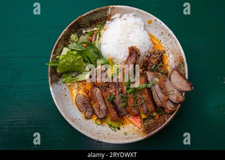 Curry di anatra alla pechinese con riso e insalata Foto Stock