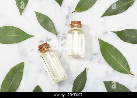 Olio essenziale Bay laurel su tavola di marmo. Olio di baia su bottiglia di vetro con contagocce Foto Stock