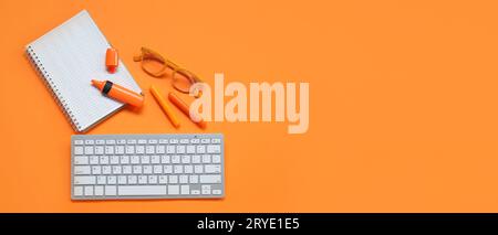 Notebook con occhiali, pennarelli e parola chiave per computer su sfondo arancione con spazio per il testo Foto Stock