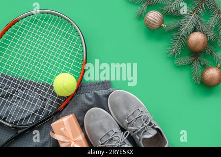 Cornice realizzata con attrezzatura da tennis con decorazioni natalizie e regalo su sfondo verde Foto Stock