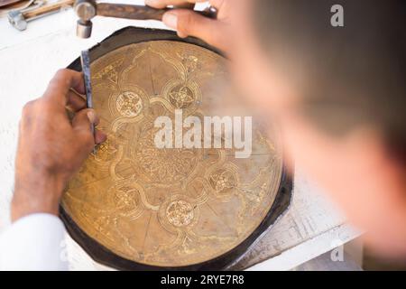 Chaser di rame al lavoro Foto Stock