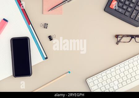 Vista dall'alto di una scrivania con smartphone, tastiera e forniture per ufficio Foto Stock