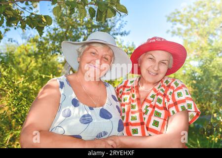 Passeggia in giardino. Due migliori amiche in pensione camminano felicemente in giardino. Foto Stock