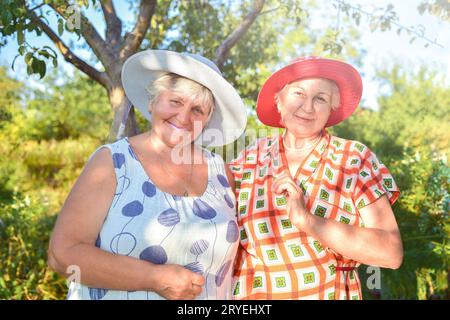 Passeggia in giardino. Due migliori amiche in pensione camminano felicemente in giardino. Foto Stock