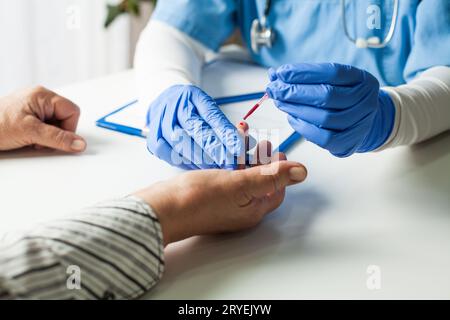 Medico NHS UK che preleva il campione di sangue del paziente Foto Stock