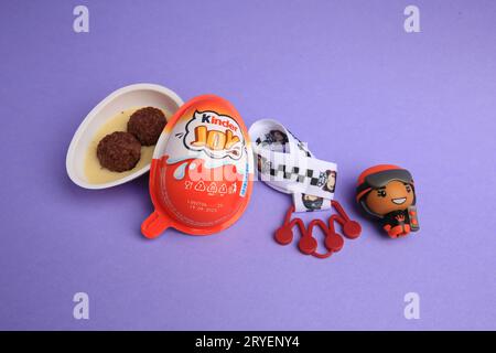 Sveti Vlas, Bulgaria - 30 giugno 2023: Uovo Kinder Joy con caramelle dolci e giocattolo su sfondo viola Foto Stock