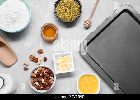 Ingredienti diversi per preparare deliziosi baklava su un tavolo con texture grigia, piatti Foto Stock