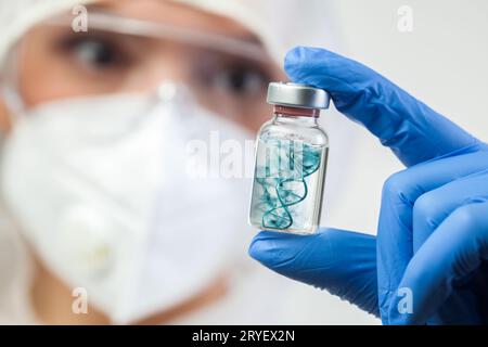 Concetto di vaccino contro il coronavirus, medico scienziato di laboratorio medico del Regno Unito che detiene fiala di vetro contenente il vaccino COVID-19 Foto Stock