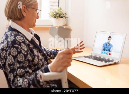 Anziana donna anziana in pensione che parla con medico di sesso femminile tramite videochiamata di telemedicina virtuale Foto Stock