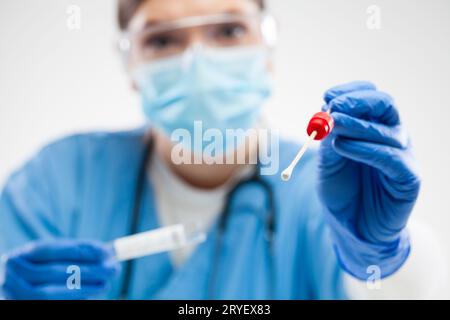 Lavoratore medico di prima linea femminile che tiene il bastone di tamponamento della gola o del naso Foto Stock