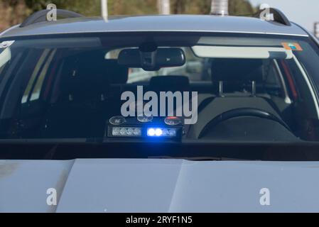 Auto della polizia non contrassegnata con luce blu accesa Foto Stock
