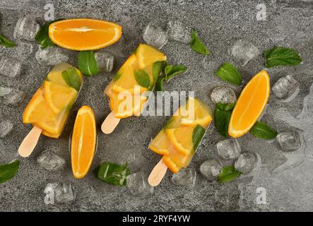 Ghiaccioli per gelato all'arancia e alla menta sul tavolo Foto Stock