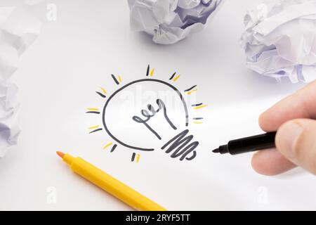Concetto di idea brillante. Luce di disegno a mano sulla carta e carta sgualcita. Concetto di processo creativo Foto Stock