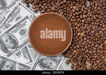 Caffè macinato in una piastra di legno isolata su chicchi di caffè e banconote in dollari di fondo. Vista dall'alto Foto Stock