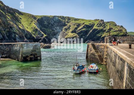 22 maggio 2023: Mullion Cove, Cornovaglia, Regno Unito - la foce del porto a Mullion Cove, un piccolo porto di pescatori sull'aspra penisola di Lizard. Foto Stock