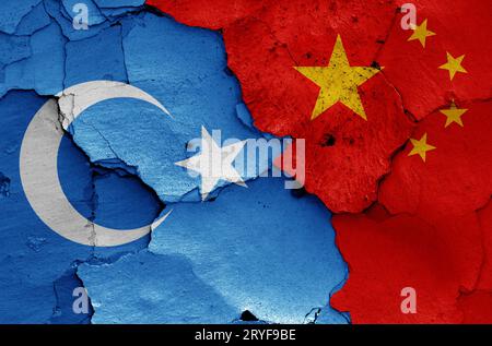 Bandiere del Turkestan orientale e della Cina dipinte su un muro incrinato Foto Stock