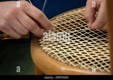 Tessitura del cestello in un'officina riparata Foto Stock