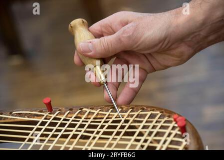 Tessitura del cestello in un'officina riparata Foto Stock