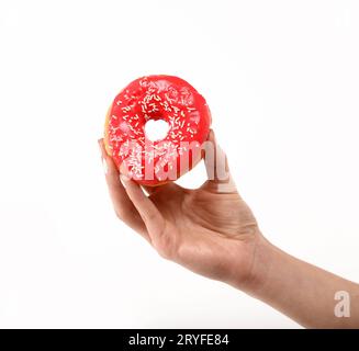 La mano della donna tiene la ciambella rossa sopra il bianco Foto Stock