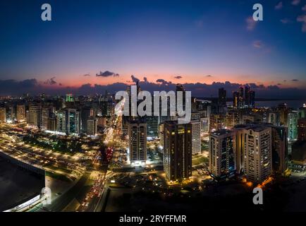 Vista aerea sul paesaggio urbano di Abu Dhabi al tramonto Foto Stock