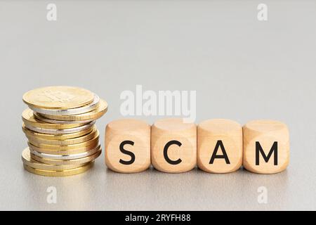 Concetto di truffa della criptovaluta. Monete cripto impilate e blocchi di legno con testo. Spazio di copia Foto Stock