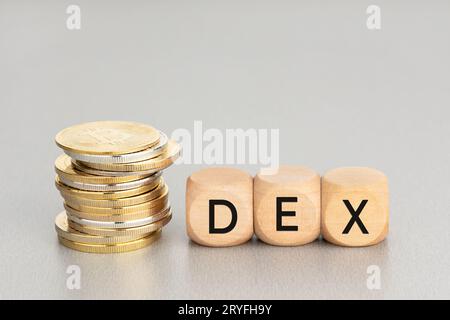 DEX o concetto di scambio crittografico decentralizzato. Monete cripto impilate e blocchi di legno con testo. Spazio di copia Foto Stock