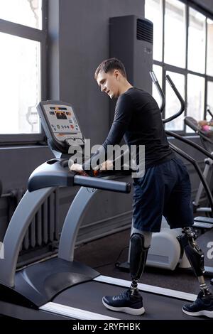 giovane uomo attivo con grande forza di volontà che lavora al centro sportivo, mantenetevi in forma. non mollare mai. vista laterale sull'intera lunghezza Foto Stock