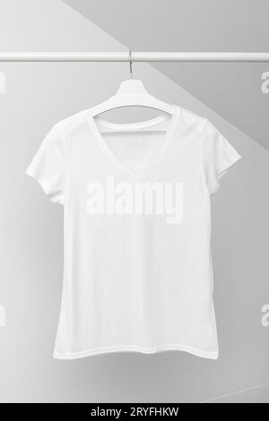 Gruppo di t-shirt assortite appese a grucce bianche. Appendiabiti Foto Stock