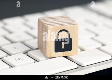 Concetto di protezione della sicurezza del computer. Protezione contro i cyber attacchi. Icona lucchetto chiuso sul blocco di legno della tastiera del computer Foto Stock