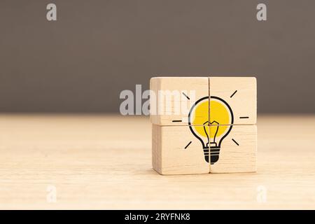 Idea, soluzione e concetto creativo. Icona della lampadina su un gruppo di blocchi di legno. Spazio di copia Foto Stock