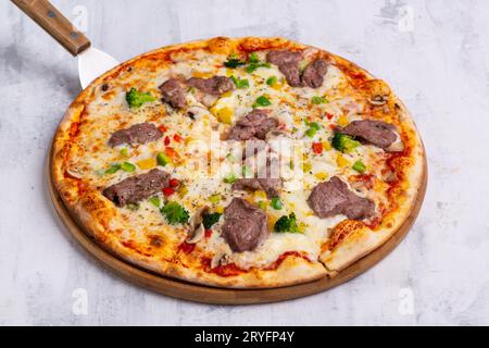 Primo piano di una pizza appena sfornata su un vassoio rotondo Foto Stock