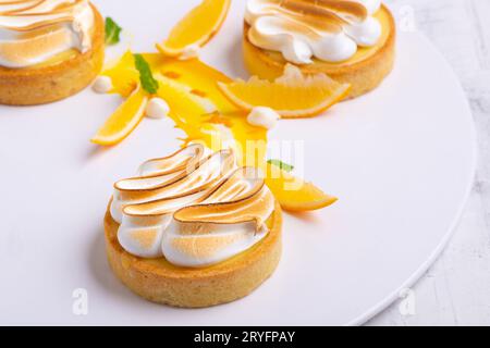 Stuzzicanti tartine di limone con meringa servite su un piatto bianco Foto Stock