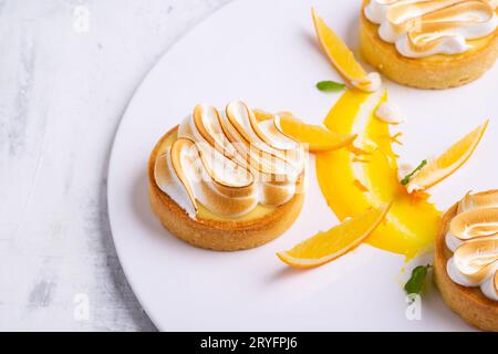 Stuzzicanti tartine di limone con meringa servite su un piatto bianco Foto Stock