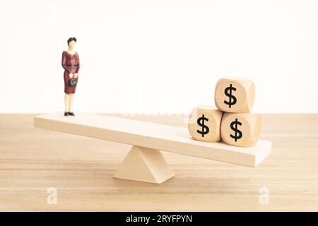 Concetto di equilibrio tra vita e lavoro o denaro. Figurine uomo d'affari e simbolo del dollaro su blocchi di legno su seesaw di legno Foto Stock