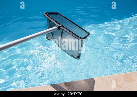 Rete Skimmer che pulisce una piscina Foto Stock