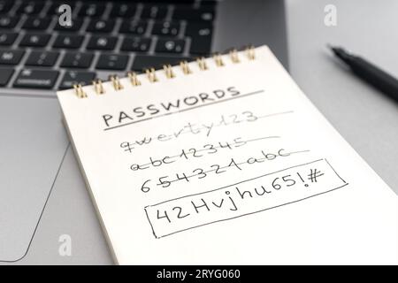 Concetto di password di protezione avanzata del computer. Modifica di una password facile debole per una password sicura. Testo scritto a mano sul blocco note sul computer portatile Foto Stock