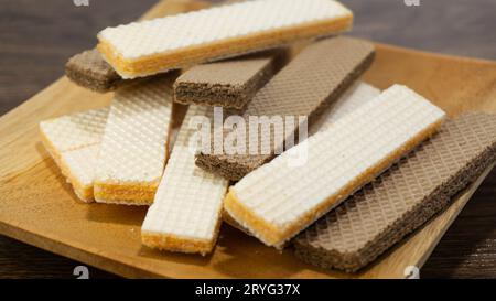 Wafer di formaggio e wafer di cioccolato serviti su un piatto di legno su un tavolo di legno Foto Stock