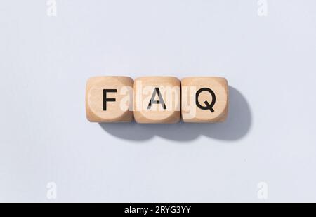 FAQ o Domande frequenti. Testo su blocchi di cubo di legno isolati su sfondo grigio Foto Stock