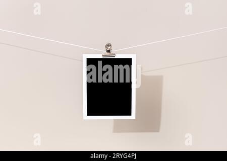 Cornice fotografica istantanea vintage vuota appesa su una corda. Modello Foto Stock